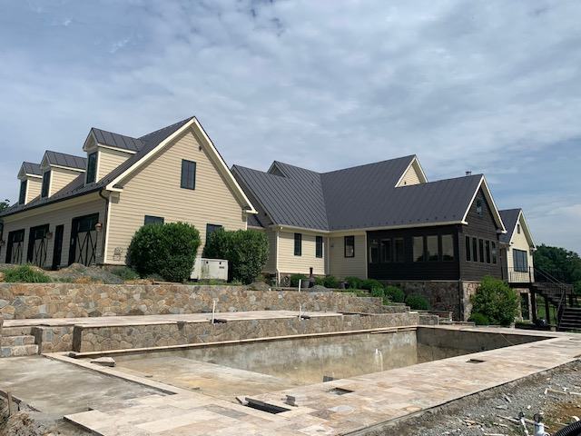 dark standing seam metal roofing panels on large residential project