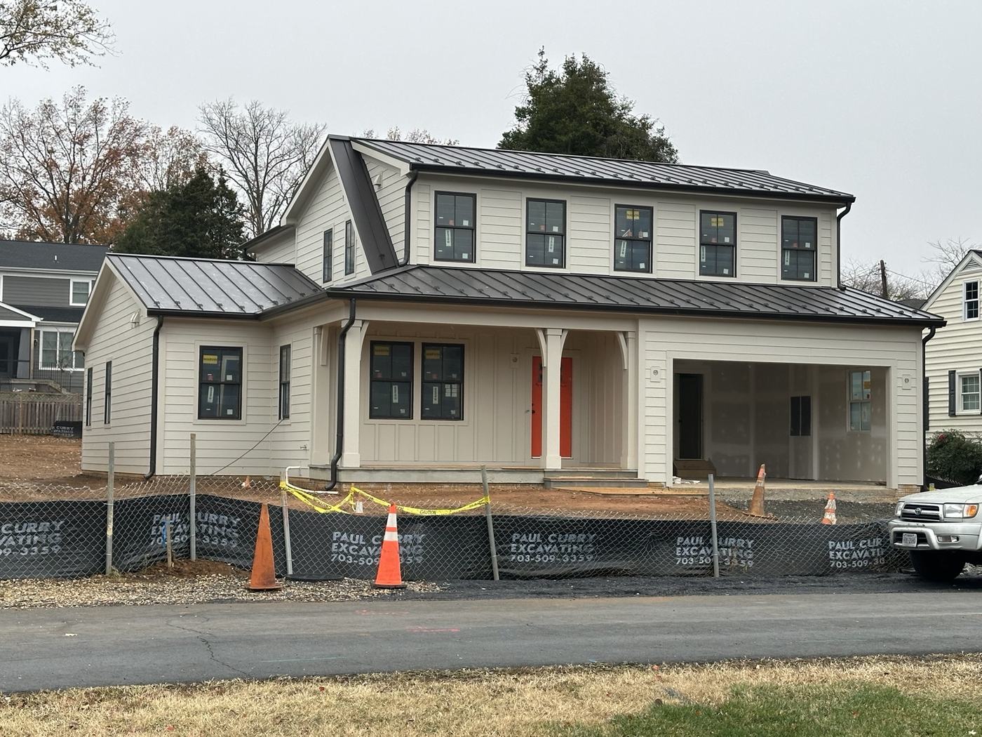 farmhouse with red standing seam metal roof and porch roof panels