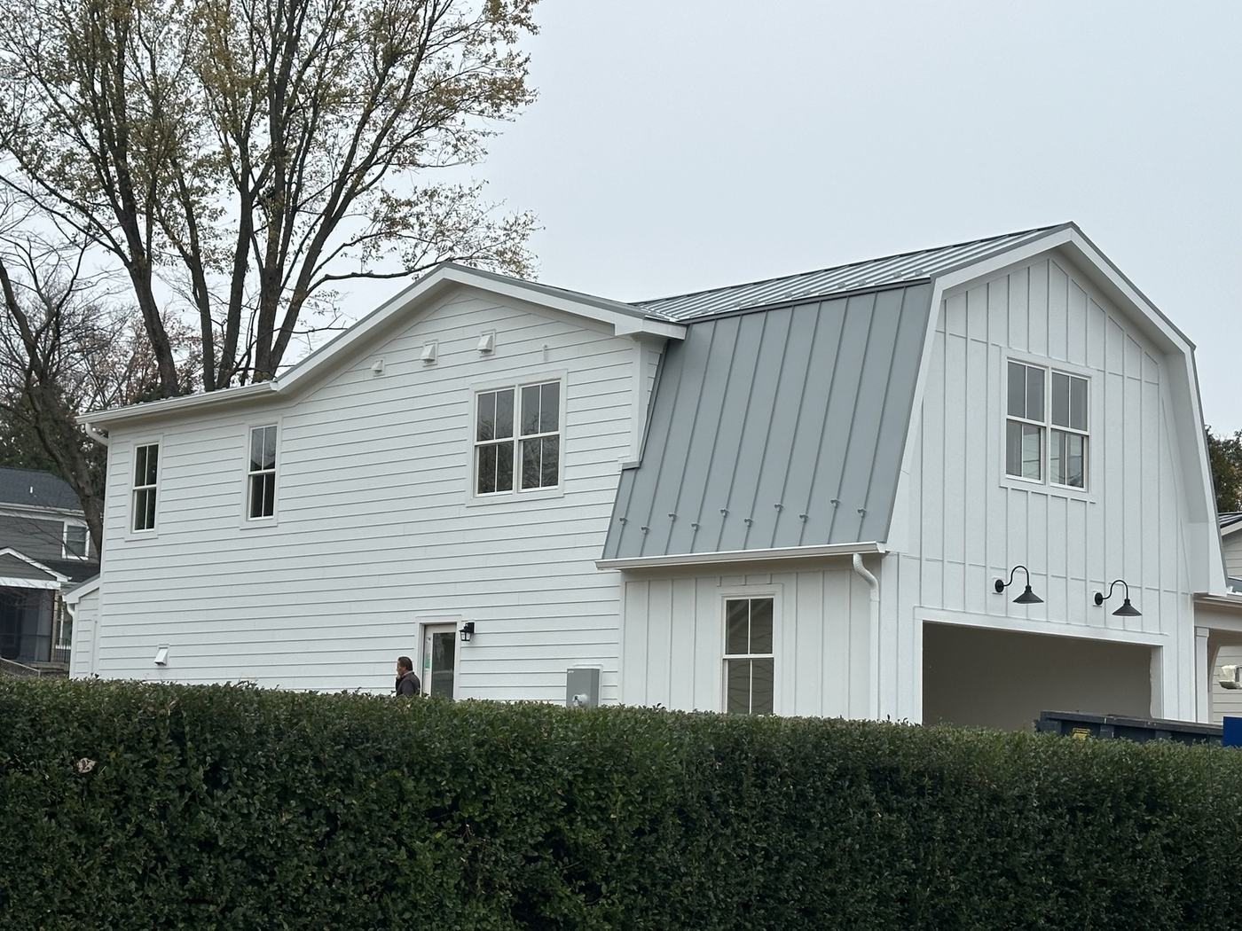 blue siding house with dark standing seam metal roof panels
