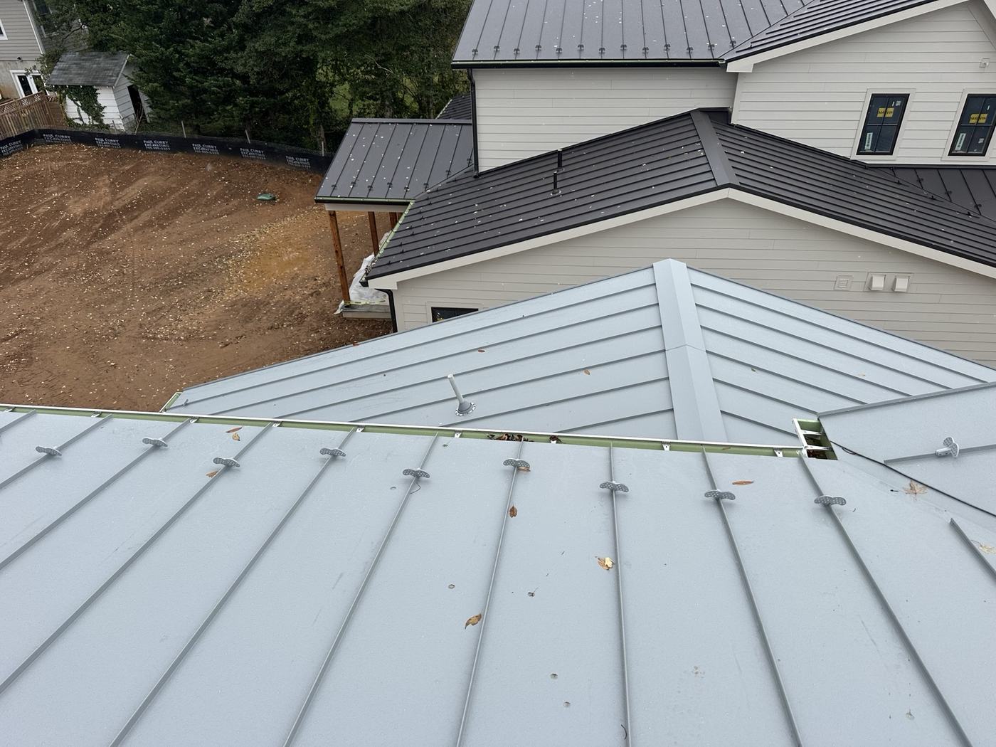 white home with gray standing seam metal roof panels