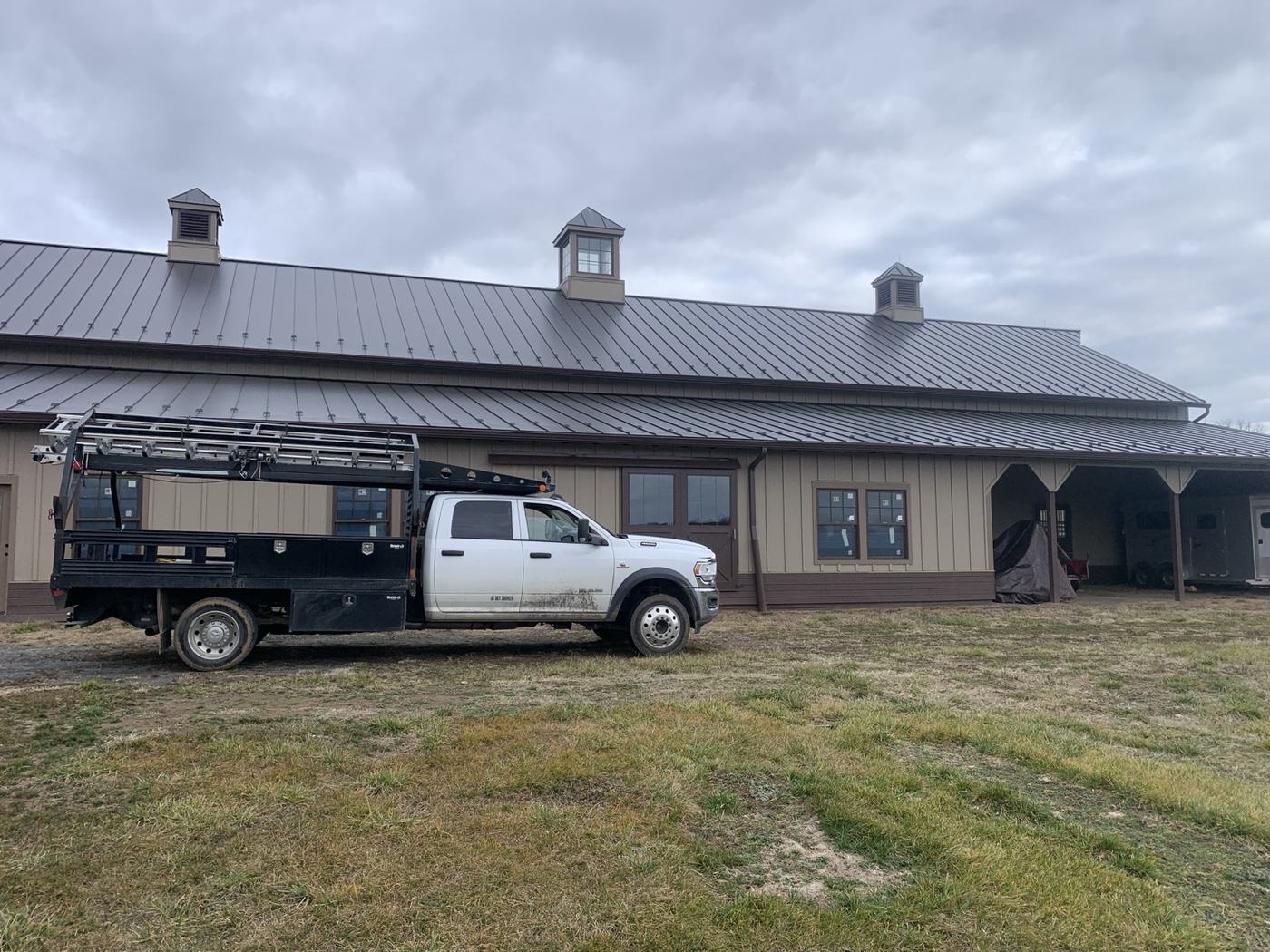 white modern farmhouse with silver standing seam metal roof and black windows